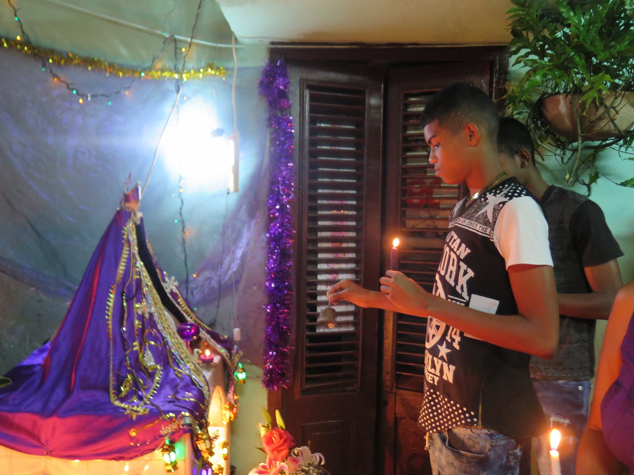 san lazaro, saint lazaro, celebration, worship, religion, santeria, catholicism, catholic, cuba, cuban, cuban streets, cuban celebration, streets of cuba, saint, patron saint of suffering, caribbean island, worshippers, boy, streets of cuba, cuban street altar, altar, candles